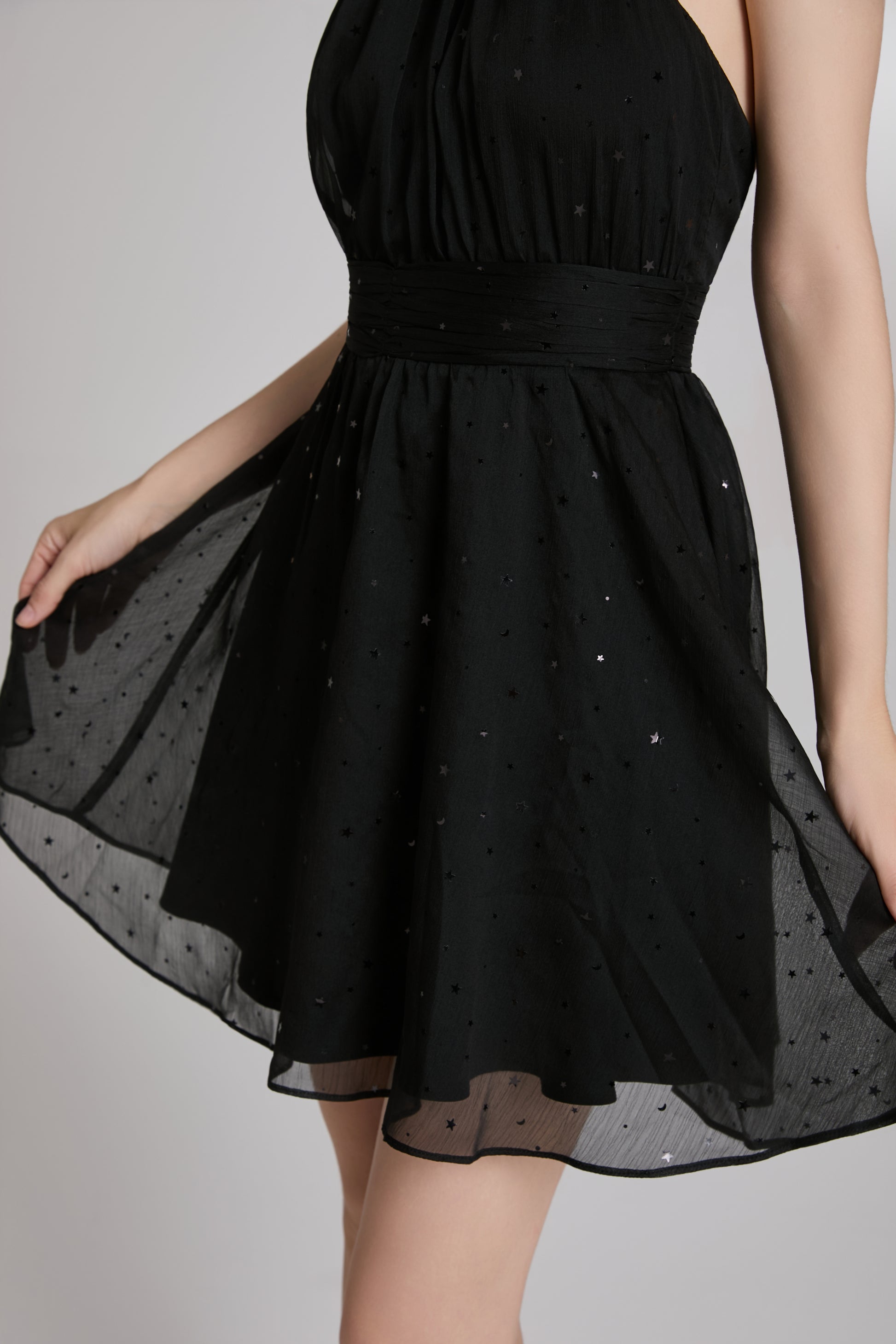 Black dress with sheer overlay on a plain background